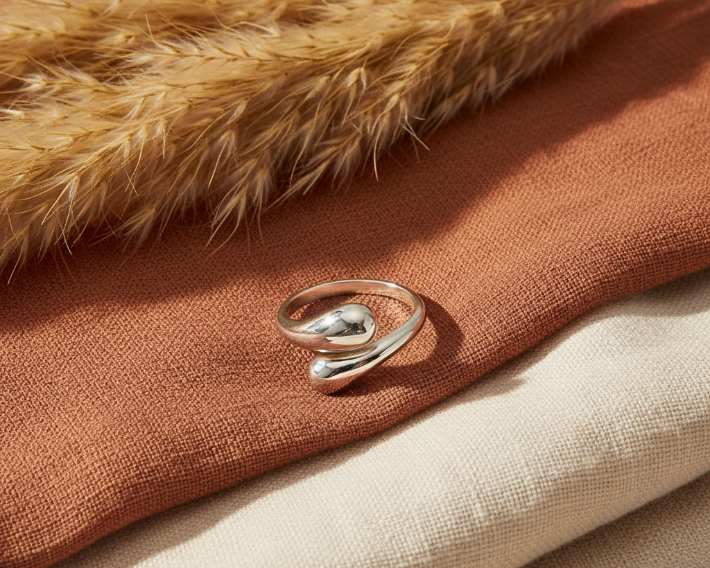 Silver geometric open ring on boho background with pampas grass and terracotta fabric