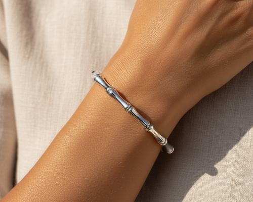 Silver bamboo bangle bracelet worn on wrist, editorial lifestyle shot