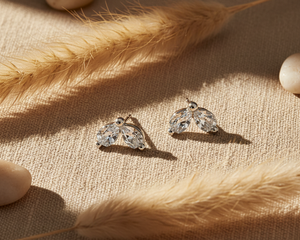 Crystal leaf stud earrings on boho linen background