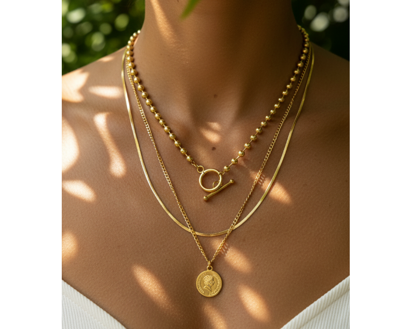Model wearing Gold Triple Coin Necklace layered set in a natural garden setting