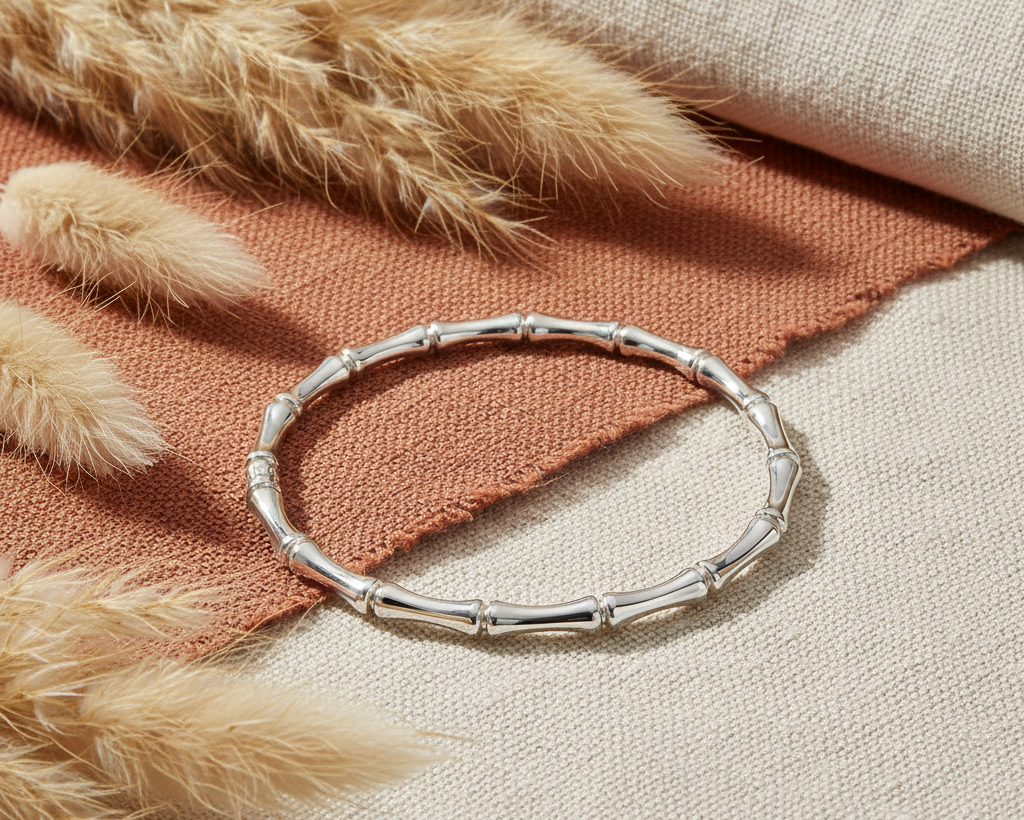 Silver bamboo bangle bracelet on boho background with pampas grass and terracotta fabric