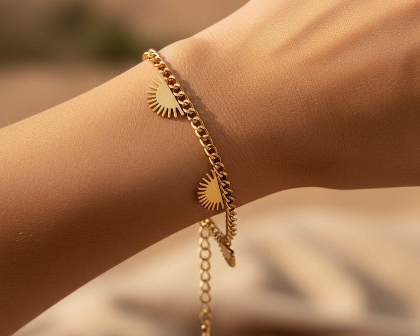 Model wearing gold sunburst charm bracelet