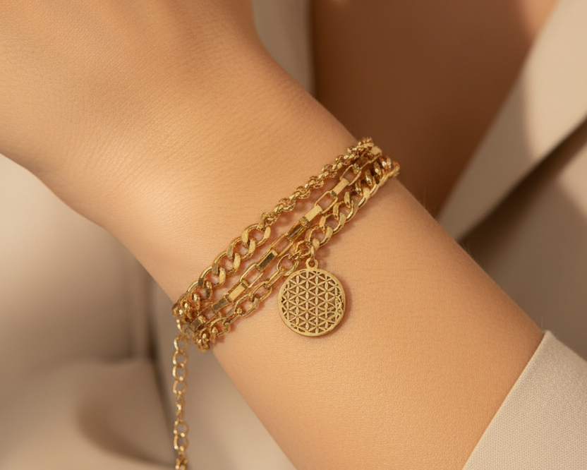 Model wearing layered gold coin bracelet