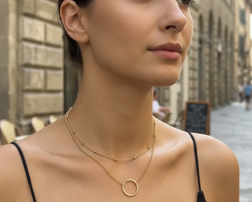Model with face wearing gold double layer necklace